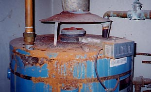 A water heater covered with rust with no leaking plumbing in sight
