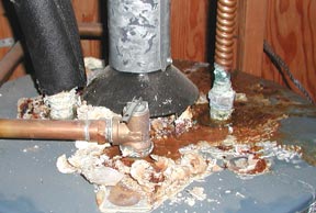 A water heater ignored too long is rusting from the outside in